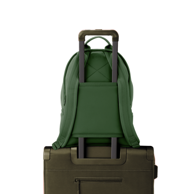 Dagne Dover medium Dakota Neoprene Backpack in a rich, classic forest green strapped to luggage with the neoprene luggage-handle sleeve.
