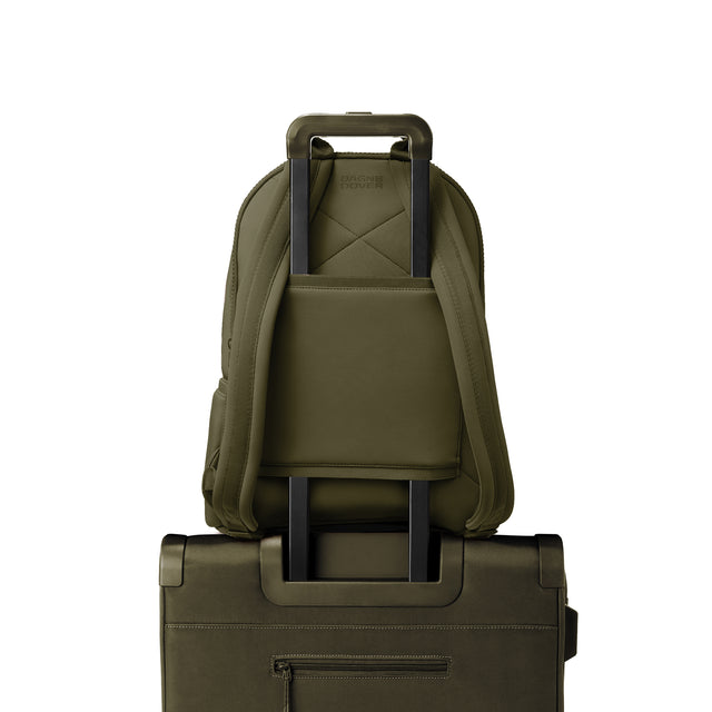 Dagne Dover large Dakota Neoprene Backpack in dark moss strapped to luggage with the neoprene luggage-handle sleeve.