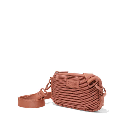 Dagne Dover Mara Phone Sling in warm dust pink air mesh seen from an angle, showing the adjustable shoulder strap drop.