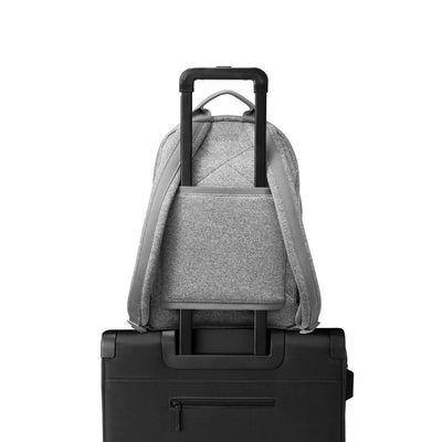 Dagne Dover medium Dakota Neoprene Backpack in grey strapped to luggage with the neoprene luggage-handle sleeve.