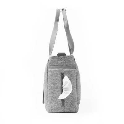 Dagne Dover large Wade Diaper Tote in grey seen from the side, with a wet wipe poking out of the slip pocket.