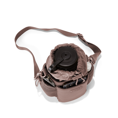 Dagne Dover Sloan Water Bottle Sling in a muted mauve seen from above containing a water bottle and accessories hover