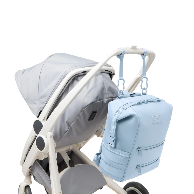 Dagne Dover Large Indi Diaper Backpack in an airy, lighter sky blue attached to a stroller.
