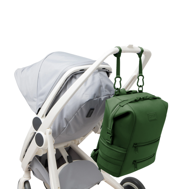 Dagne Dover Large Indi Diaper Backpack in a rich, classic forest green attached to a stroller.
