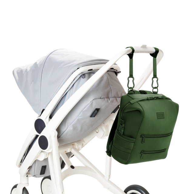 Dagne Dover medium Indi Diaper Backpack in a rich, classic forest green attached to a stroller.
