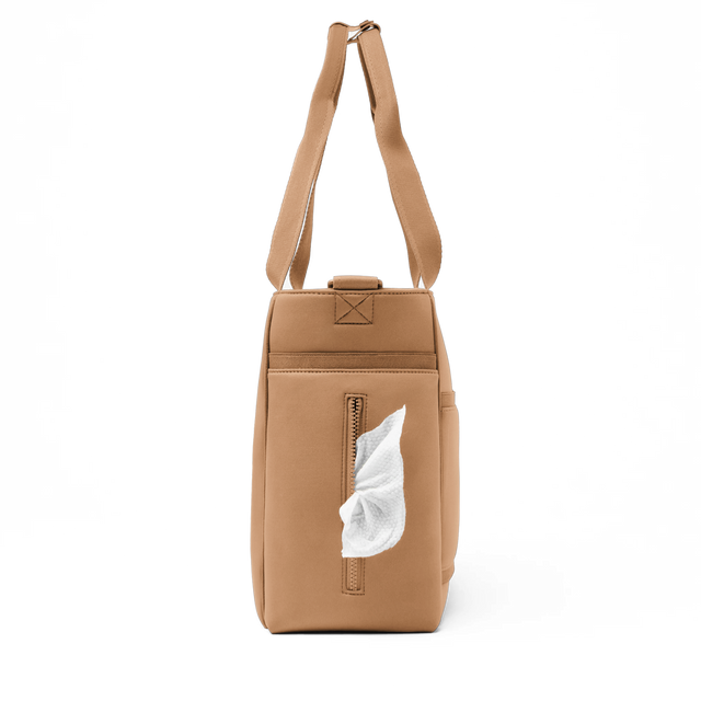 Dagne Dover large Wade Diaper Tote in camel brown seen from the side, with a wet wipe poking out of the slip pocket.