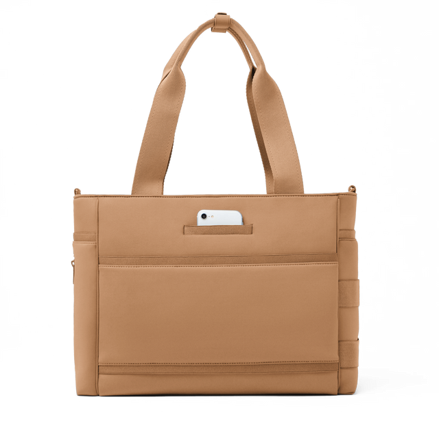 Dagne Dover large Wade Diaper Tote in camel brown seen from the back with a phone in the exterior phone pocket.