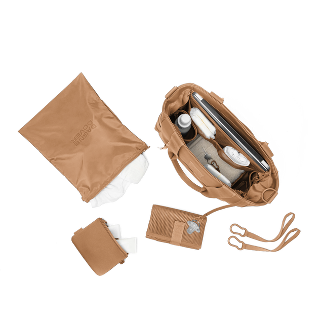 hover - Dagne Dover large Wade Diaper Tote in camel brown from above, alongside the changing mat, neoprene pouch, and water resistant zipper bag.