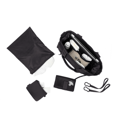 hover - Dagne Dover large Wade Diaper Tote in black seen from above, alongside the changing mat, neoprene pouch, and water resistant zipper bag.