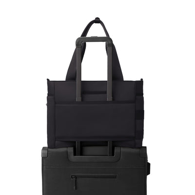 Dagne Dover large Wade Diaper Tote in black with the neoprene luggage sleeve attached to a suitcase handle.