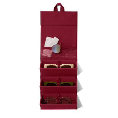 Dagne Dover Remi foldable glasses holder in spice red hung up and holding glasses. hover