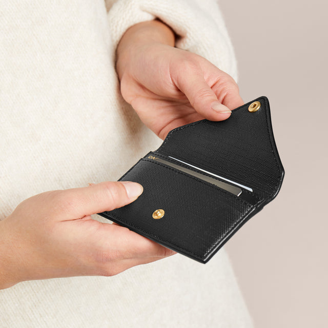 Someone opening the vegan Card Case in black.